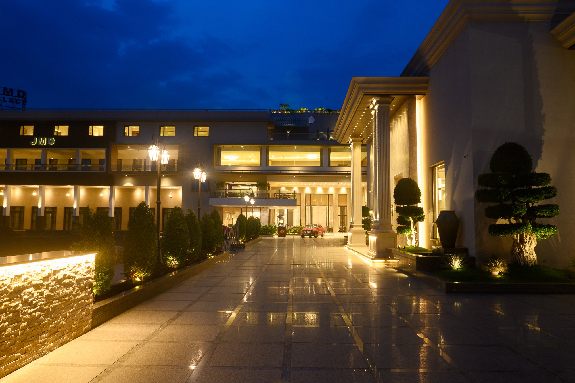 JMD Palace arrival court illuminated beneath a deep blue evening sky